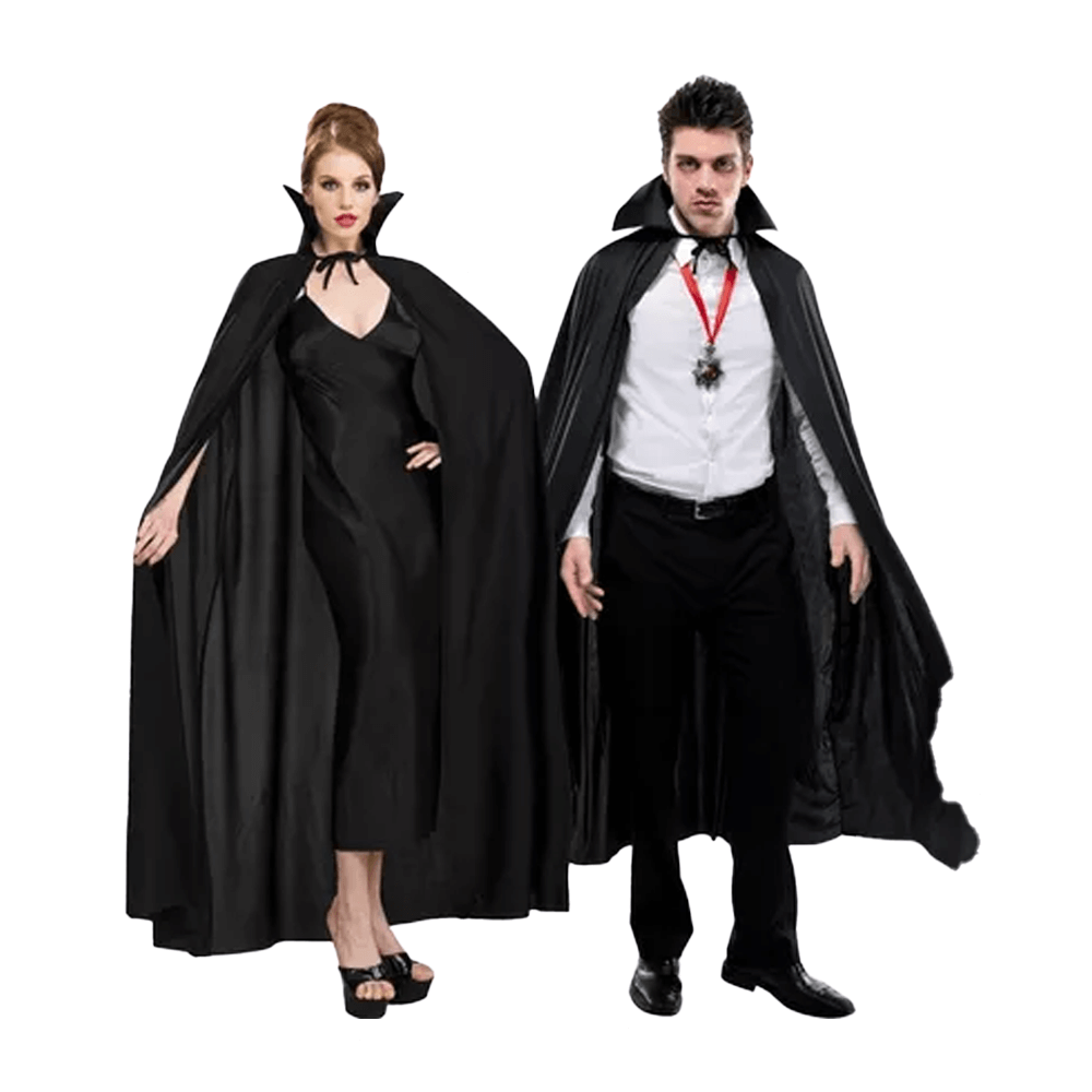 A woman and a man, evocative of theatrical vampires, stand side by side. She wears the Vegas Party Favors Adult Full Length Black Cape over her long black dress, while he rocks a vampire collar with his white shirt and black pants. They exude dark allure against a white backdrop.