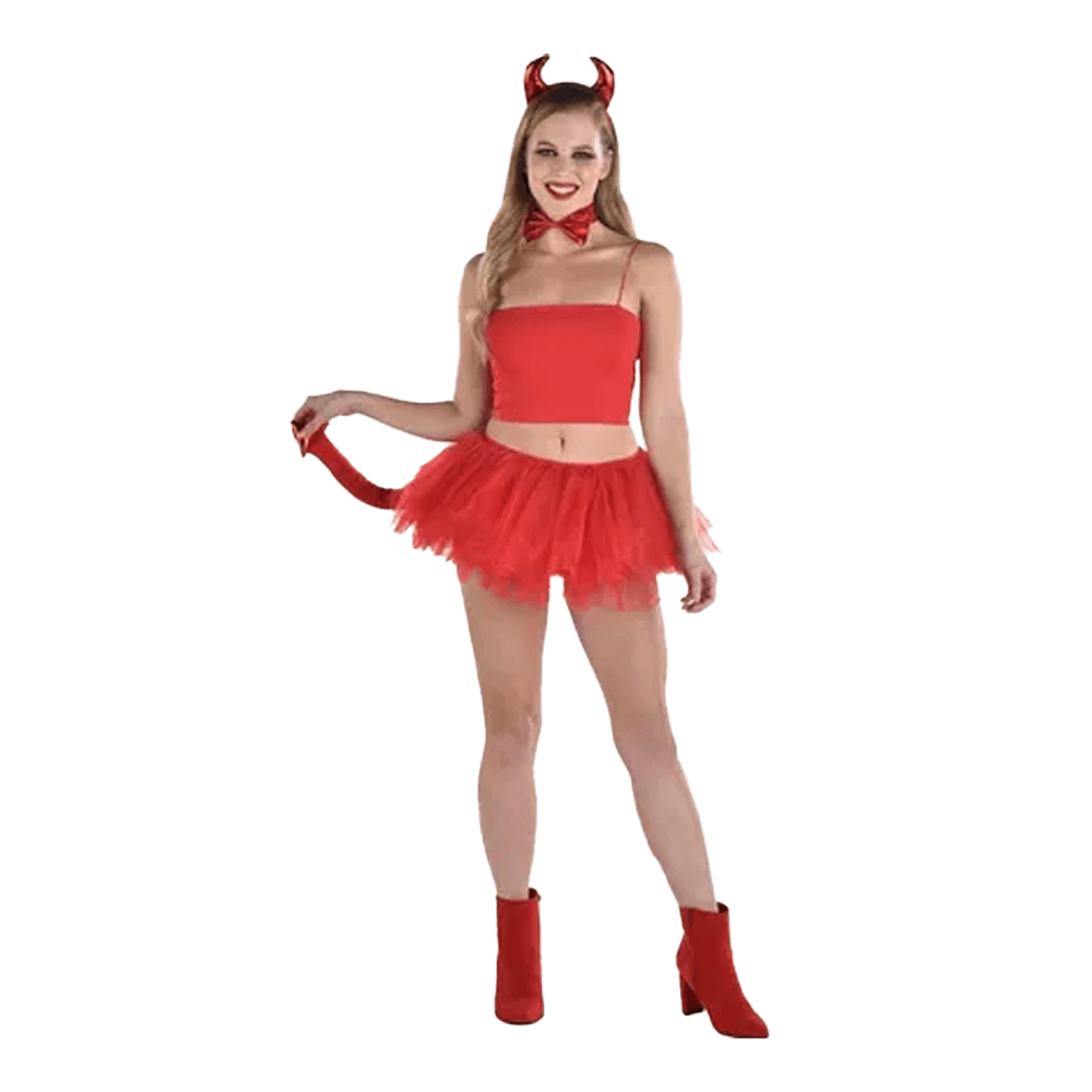 A person in the Vegas Party Favors Devil Accessory Kit, featuring red horns, a bow tie, strapless top, and playful red tutu skirt with matching boots, poses with a mischievous smile to effortlessly showcase their devilish look.