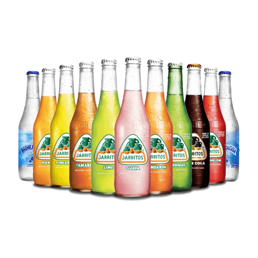 A row of colorful Jarritos Soda bottles by Vegas Party Favors, showcasing flavors like mango, pineapple, tamarind, lime, and guava. The vibrant colors form a rainbow against a plain backdrop.