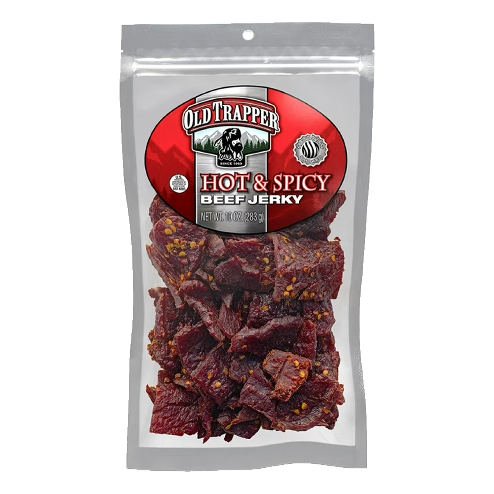 A clear package of Vegas Party Favors Old Trapper Hot & Spicy Beef Jerky is displayed, showcasing a keto-friendly snack with visible spices. The brands logo is prominently featured at the top. Enjoy this 10-ounce, high-protein, low-calorie beef jerky for lunches or between meals.