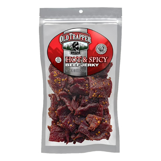 A clear package of Vegas Party Favors Old Trapper Hot & Spicy Beef Jerky is displayed, showcasing a keto-friendly snack with visible spices. The brands logo is prominently featured at the top. Enjoy this 10-ounce, high-protein, low-calorie beef jerky for lunches or between meals.